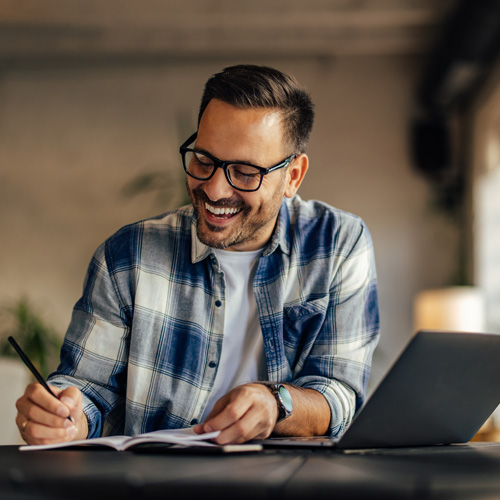 A man getting work done and feeling happy about it.