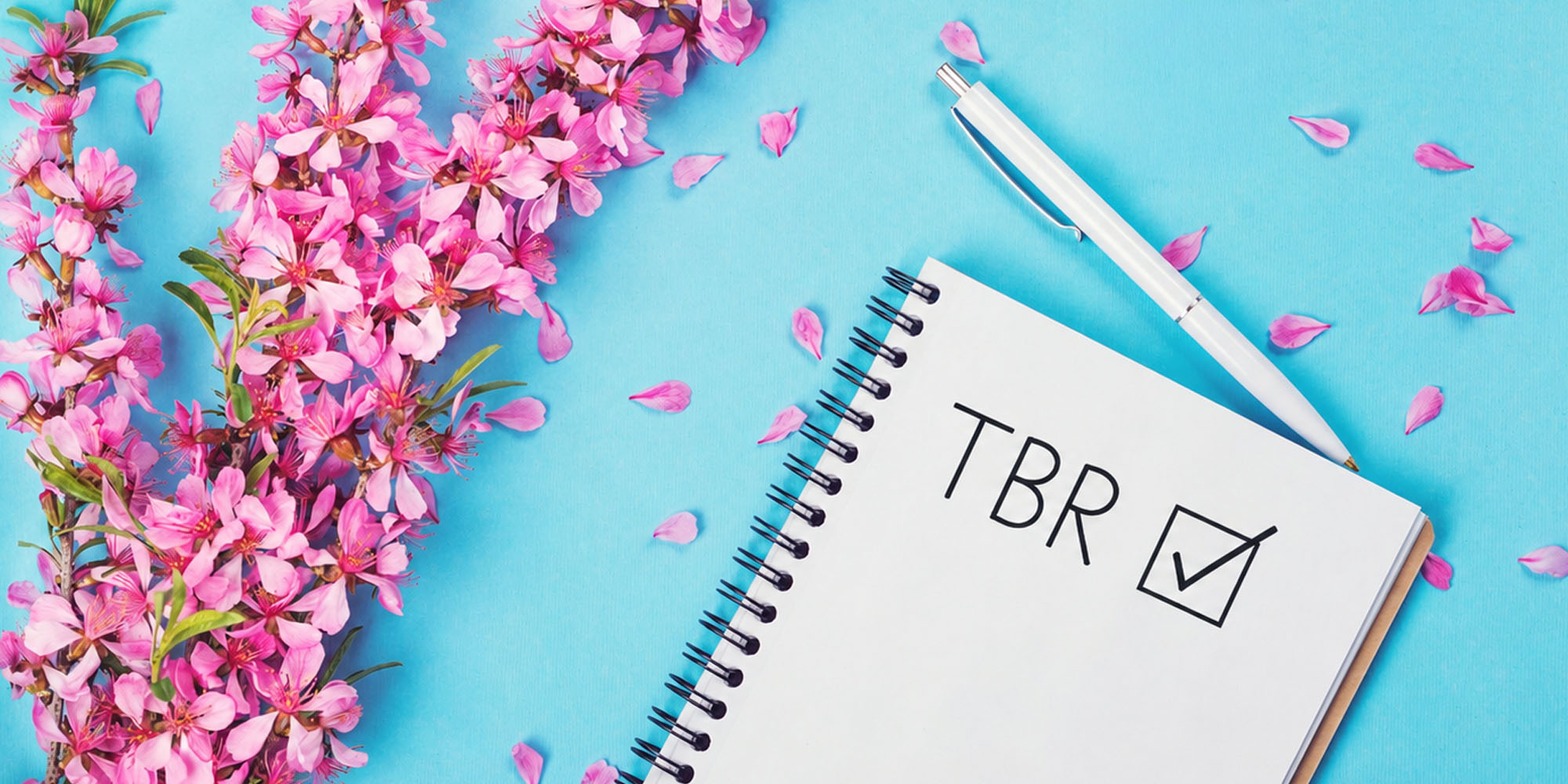 Spring flowers with a notebook that reds TBR (To Be Read) and had a check mark in the box